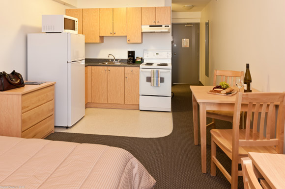 Monashee studio suites feature a queen bed with fully equipped kitchen, private bathroom, desk and air conditioning.