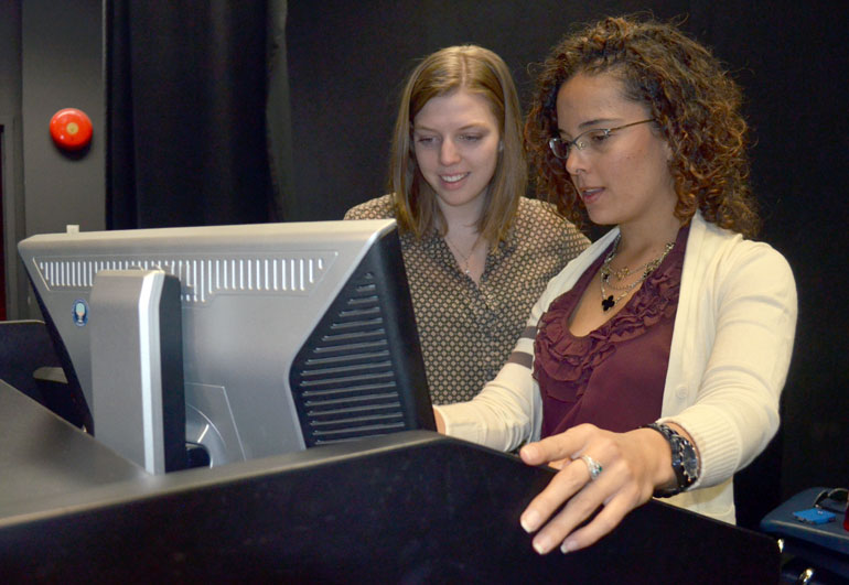 Backstage, Campus Life student volunteer Sydney Bednarik, left, goes over the audio visual format with First Year Services Coordinator Laura Prada. Campus Life is credited for coordinating IAN Talks for the past two years.