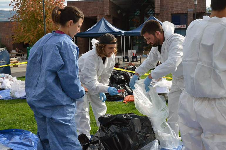 Facilities Management's Kirt Stewart (right) and two student volunteers sort through trash and recyclables at the 2014 Campus Waste Audit.