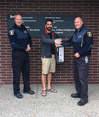 Campus Security's Mike Gesi (left) and Paul Hipsey (right) return a stolen portable weather station to Environment Canada meteorologist Doug Lundquist.