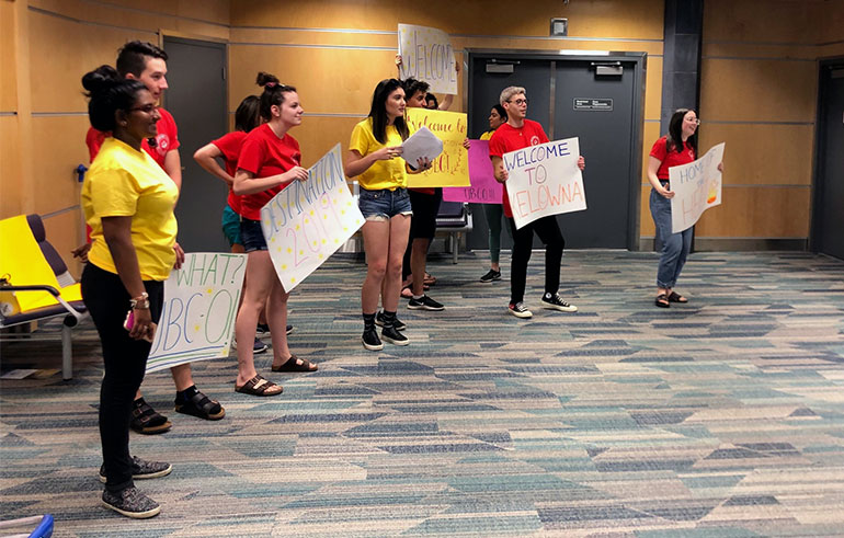 Peer Leaders and Senior Peer Leaders form a greeting squad at the airport