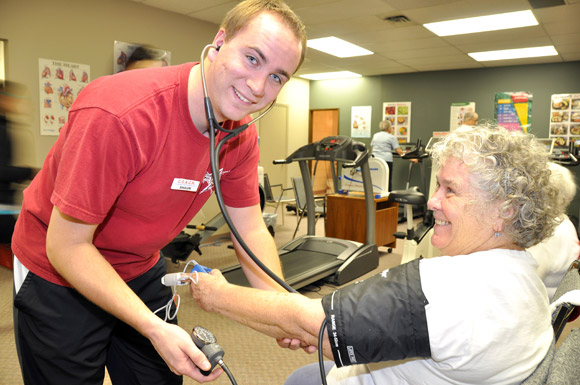 Fourth-year UBC Human Kinetics student Shaun Crowell takes the blood pressure of a client at COACH as part of his volunteer work term.