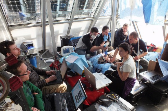 Team members of Everest 2012: UBC’s International Research Expedition, conduct one of several human health experiments at Mount Everest’s Pyramid International Laboratory. Prof. Phil Ainslie, upper right corner of photo, observes the research team.