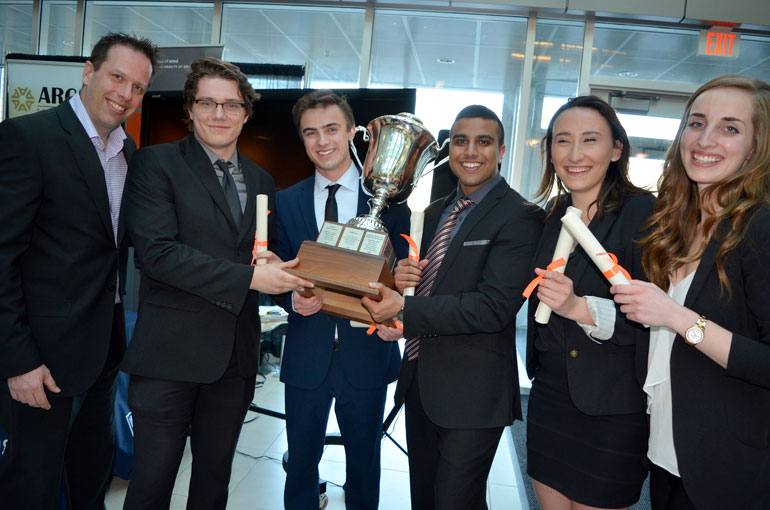 Argus Properties Vice-President of Finance and Accounting Justin Bierwirth and Management students Kyle Patan, Cameron Mahler, Gopal Patel, Jenel McKenney and Audrey Kaake hold the Argus Cup after winning the 2016 Live Case Challenge.