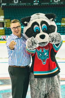 HatTrick participant Kevin Lavigne and poses with Kelowna Rockets mascot Rocky the Raccoon. 