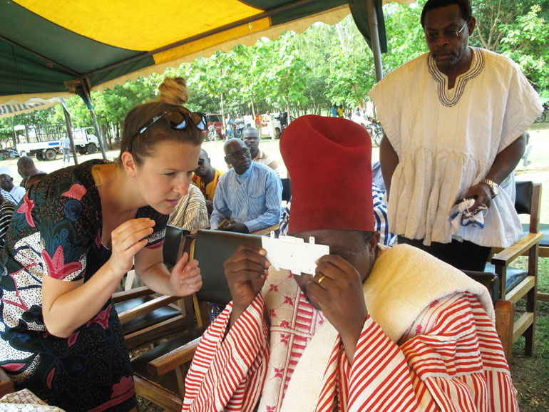 UBC Faculty of Education’s Carly Bokor shows Paramount Chief of the Nabdam Region how to use the Foldscope.