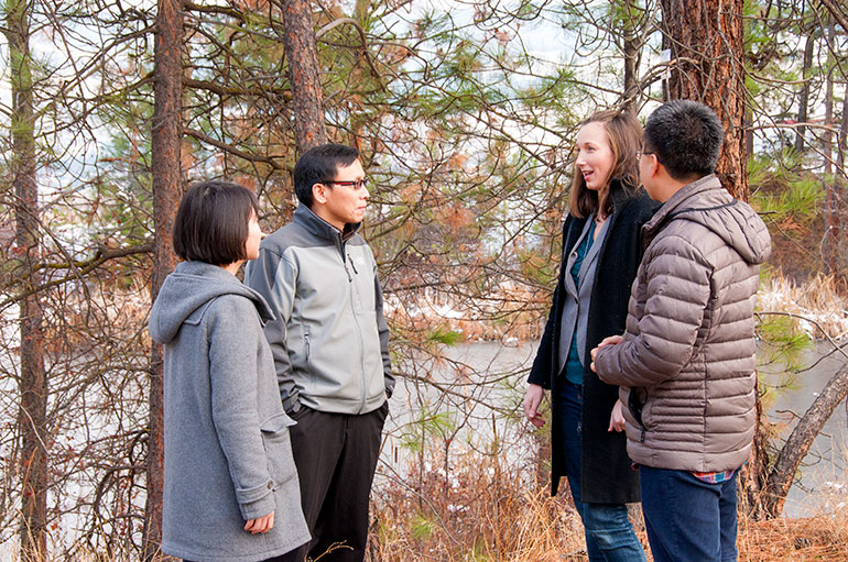 UBC researchers (from left to right) Abby Yang, Associate Professor Adam Wei, Krysta Giles-Hansen and Qiang Li discuss the role forest vegetation plays while monitoring water resources.
