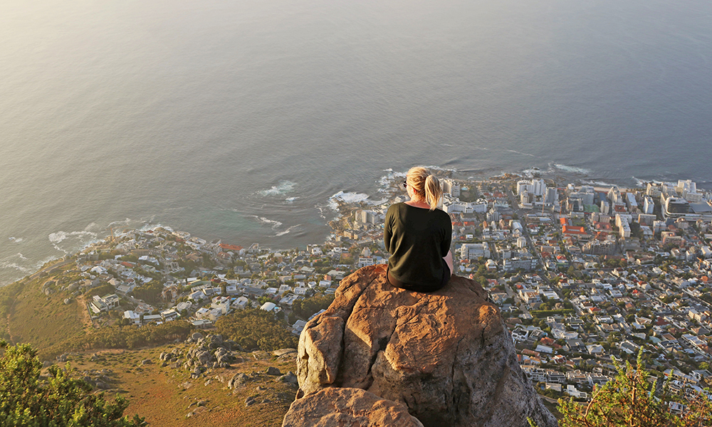 Woman sitting on a rock high above Capetown South Africa