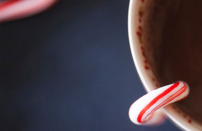 candy cane inside a mug of hot chocolate