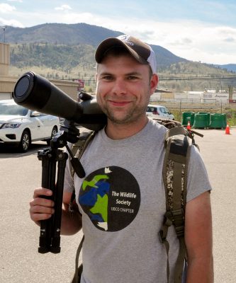Bighorn sheep researcher poses with a telescope