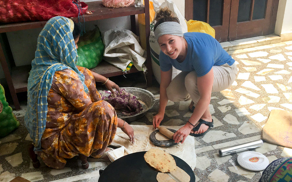 Andres Stinson helps roll dough with a local woman in India.