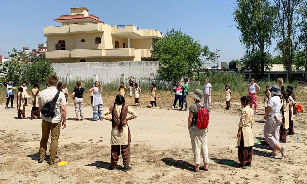 A group of UBC students playing soccer with your girls in India