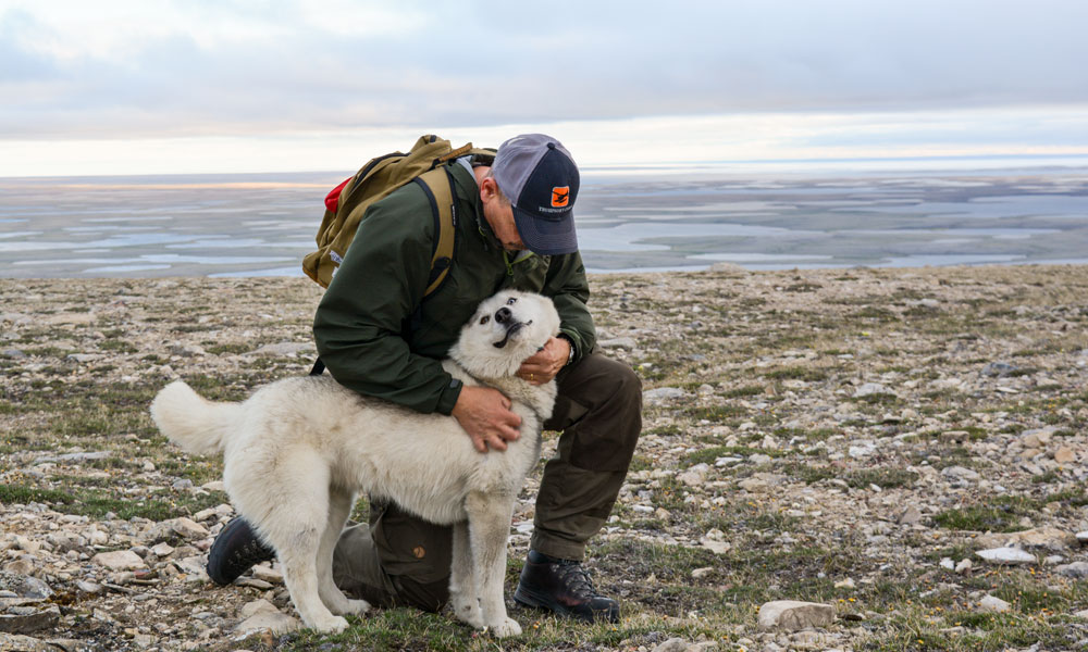 Kevin Hanna petting a husky in the Arctic