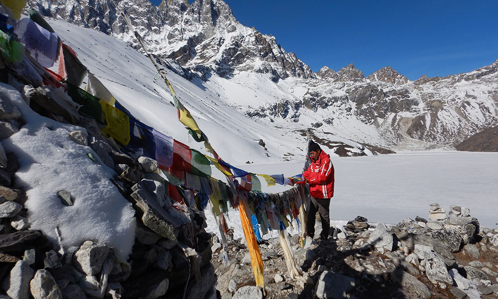 Man on mountain with Nepali prayer flags