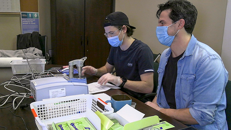 Third-year UBCO nursing student Thomas Pool works alongside community volunteer and registered nurse Sean Garden, as they check drug samples at Living Positive Resource Centre in downtown Kelowna.