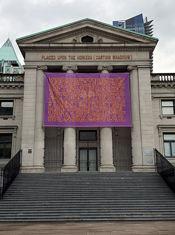 Whess Harman’s artwork, hanging outside the Vancouver Art Gallery with the current display of 215 pair of shoes symbolizing the death 215 Indigenous children, states how land acknowledgements are not enough and how they are the lowest bar in the process of truth and reconciliation for the Indigenous peoples.