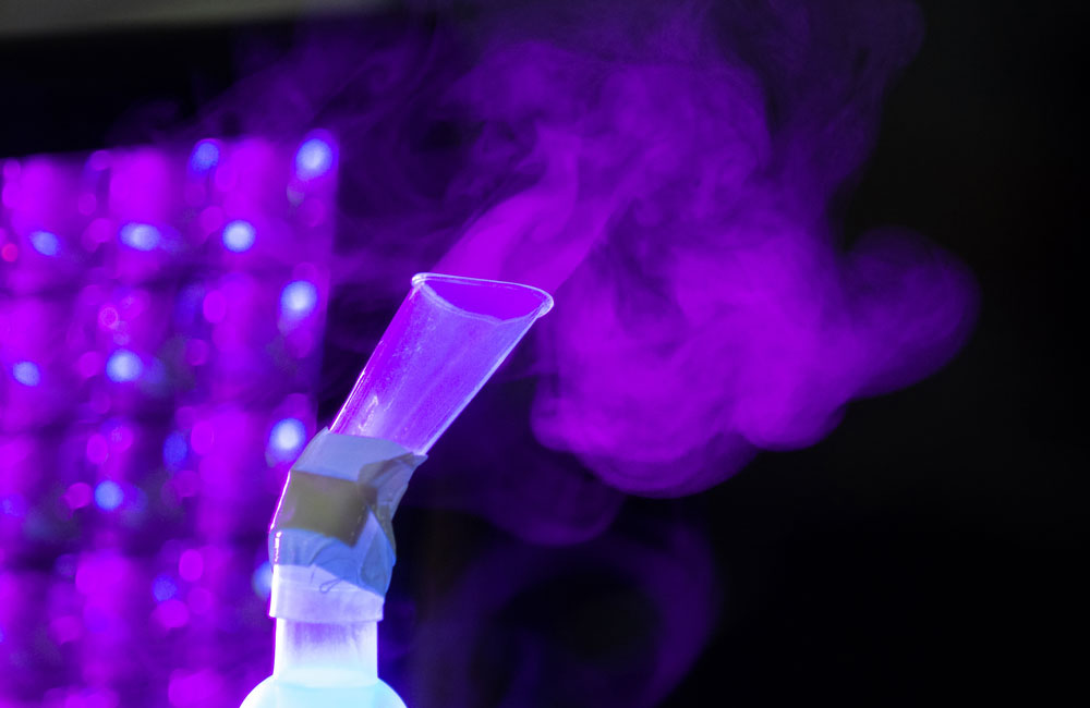 Close up of UV light highlighting vapour emitting from test tube