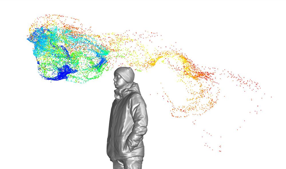 man surrounded by cloud of particles in different colours