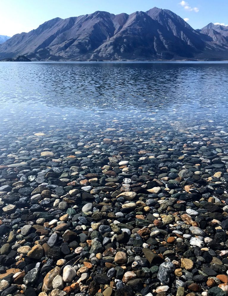 A clear lake with pebbles on the bottom