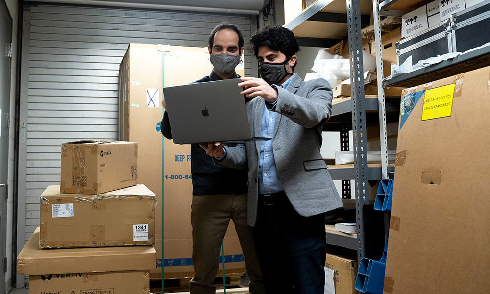 Two researchers standing in a warehouse looking at inventory