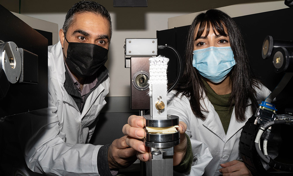 A photo of a two researchers looking at composite materials they are studying