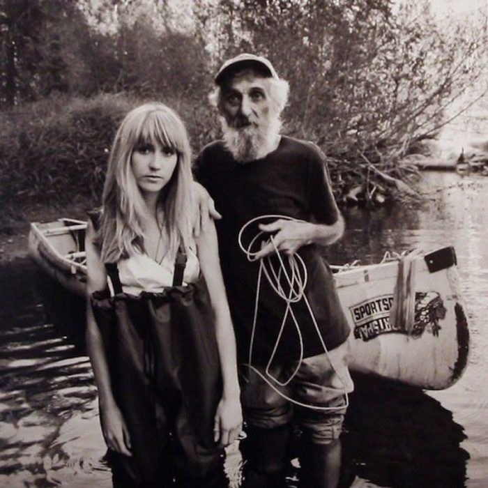 A photo of an old man and a girl standing knee deep in water