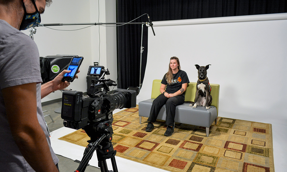 A photo of a researcher and a dog in a virtual therapy session