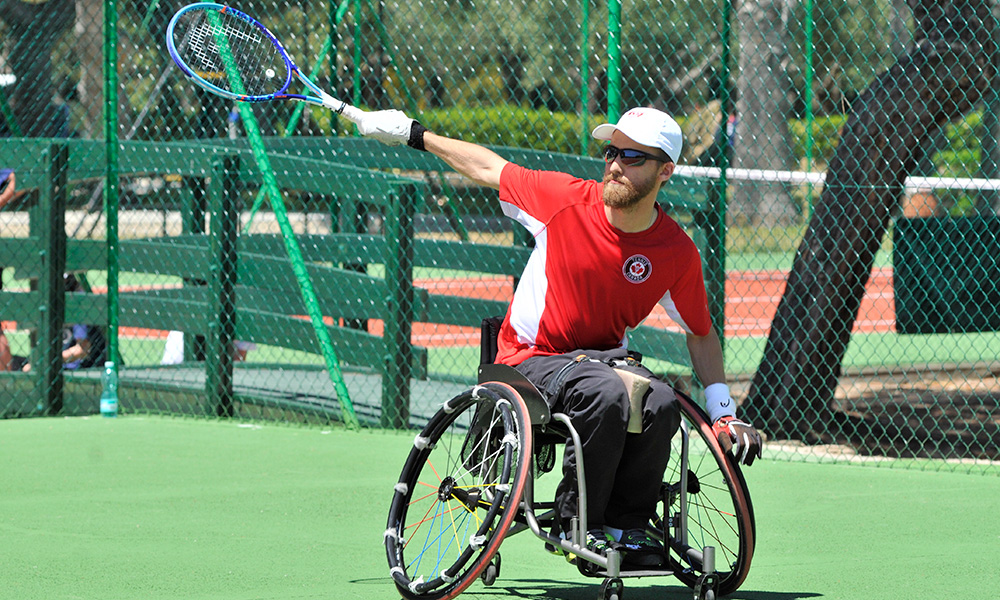 A photo of Dr. Rob Shaw playing wheelchair tennis 