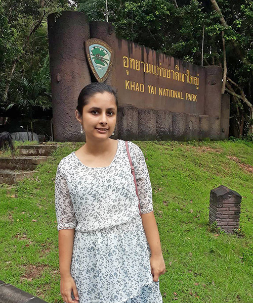 Akanksha Bhurtel standing in front of a national park sign in Thailand