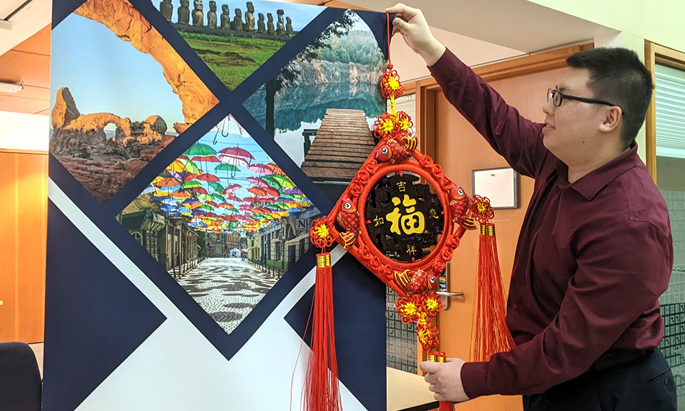 Gabriel Tan is hanging decorations for 2023 Lunar New Year