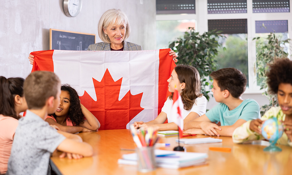 Female teacher showing Canadian flag to kids 