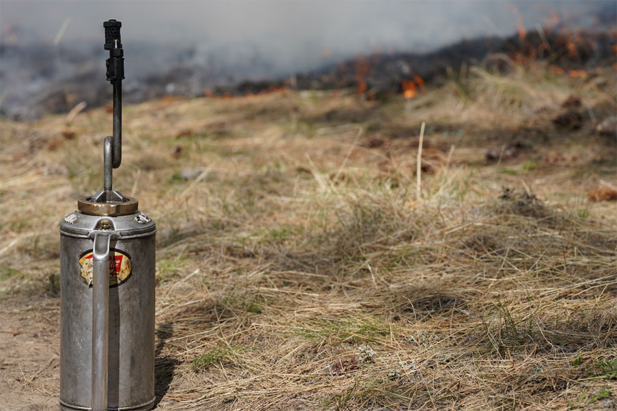 A close up of a drip torch, which is used in wildland firefighting.