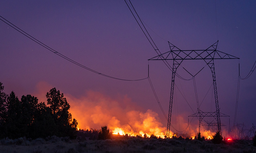 A photo of power lines being threatened by fires