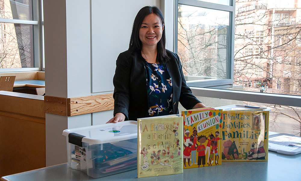A photo of Dr. Jessica Chan with a set of family literacy kits.