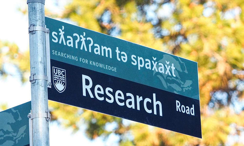 A photo of a UBCO street sign that reads "Research Road" as well as the syilx translation. 