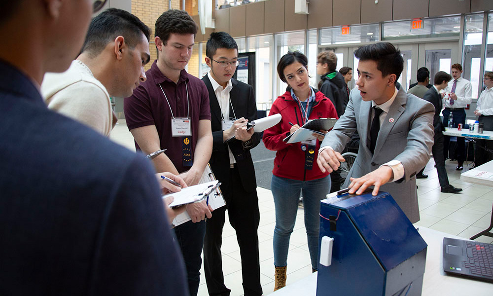 A photo of engineering students discussing their project during last year's design competition.
