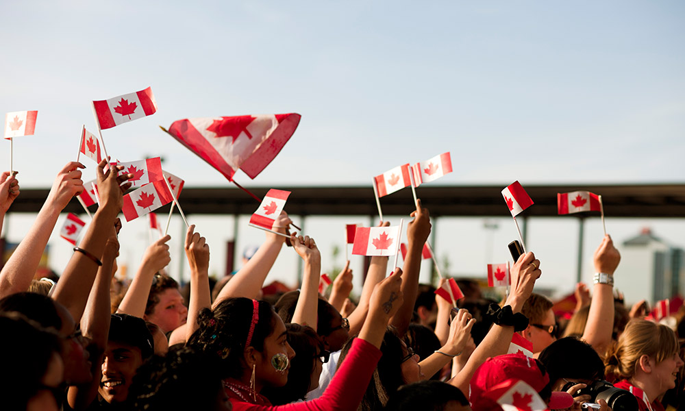New Canadian citizens wave flags to celebrate.