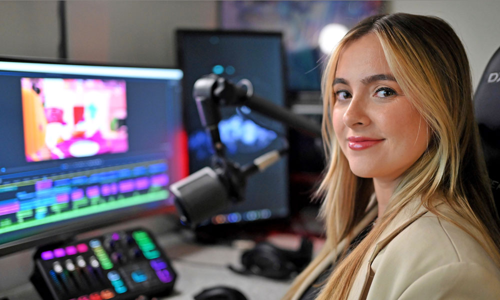 A female with blond hair sits in front of a computer